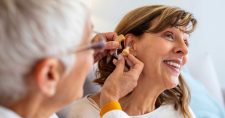 Doctor implementing a hearing device for a lady.
